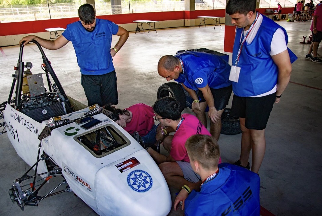 Integrantes del equipo revisan el morro del coche en el área de inspección
