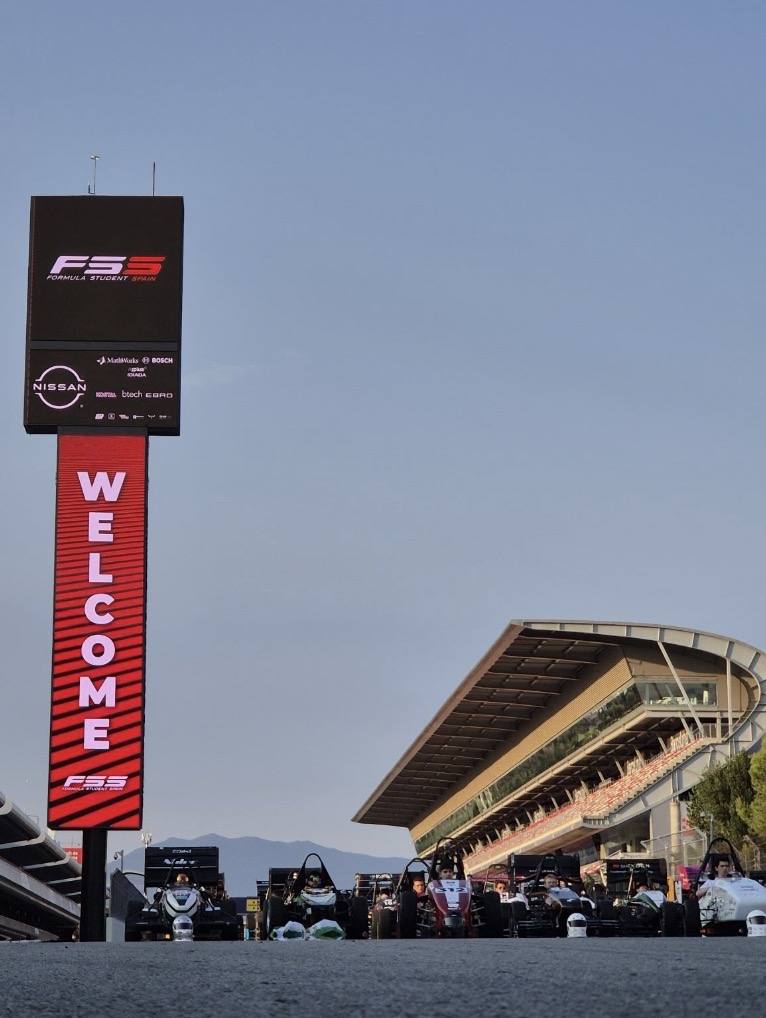 Monoplazas alineados en la recta de salida del circuito, bajo el cartel de bienvenida de Formula Student Spain