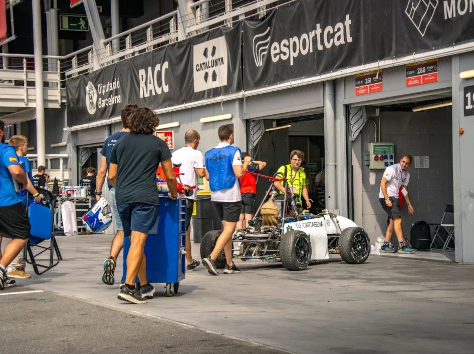 El equipo empujando el monoplaza por el pit lane del circuito